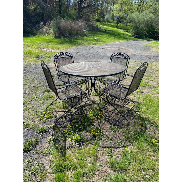 This great mid century dining set includes a 48” round iron mesh table and 4 coil spring armchairs in the Salterini...