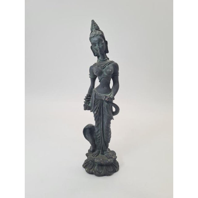 A figurine depicting a South Asian temple dancer / a figure inspired by Buddhist and Khmer art, made of patinated...