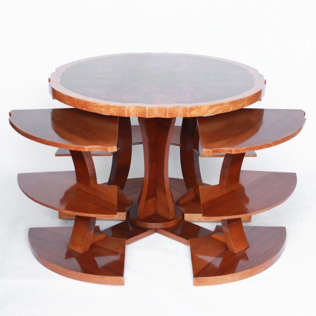 Art deco, figured walnut veneer nest of tables. A shaped table with cross-footed base and four integral side tables. Burr...