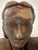 This ceramic bust presents a contemplative female figure rendered with subtle realism and earthy texture. The sculptor’s...