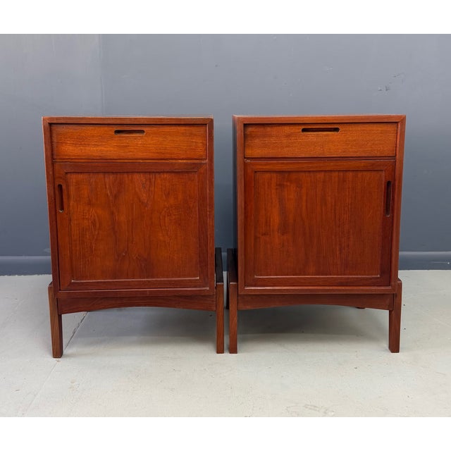 A refined pair of mid-century modern teak nightstands by William Watting, showcasing his signature balance of clean lines...
