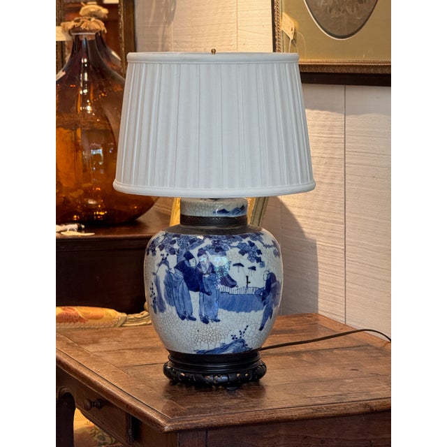 A blue and white Chinese ginger jar mounted as a lamp, painted with figures gathered in a garden beneath flowering...