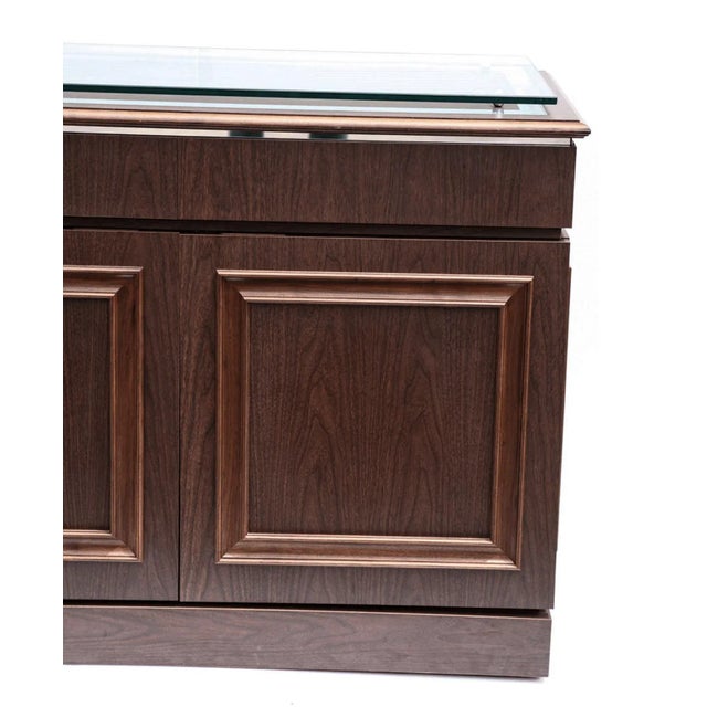 Custom sleek sideboard by Paul Laszlo made in 1973. Total of four drawers on top and two storage compartments with four...