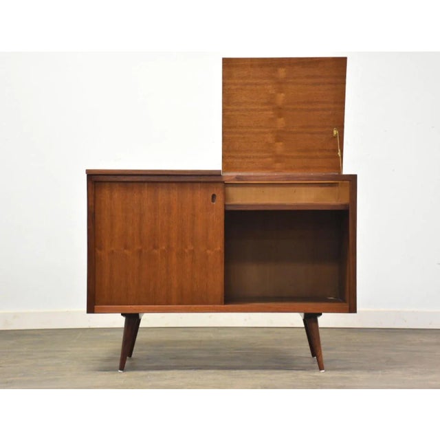 A mid century modern walnut cabinet credenza or bar with lift up tops and sliding doors. Refinished exterior. 40.25” wide....