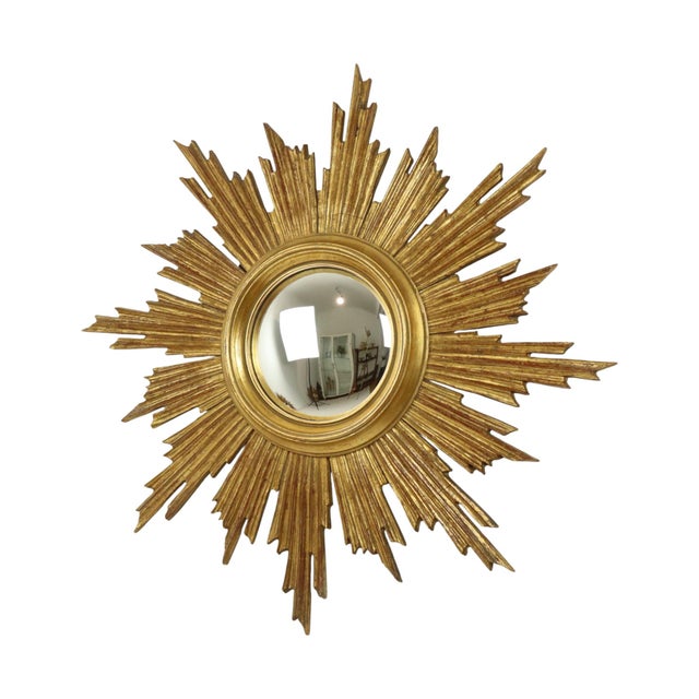 Rare wooden sunburst mirror, large format sunburst mirror with convex mirror glass; the mirror is made of wood gilded with...