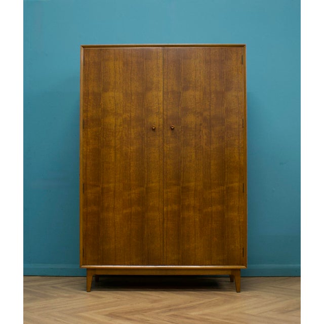 A freestanding double door teak wardrobe from Gimson & Slater. Made during the 1960s It's fitted with two clothes rails...