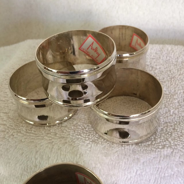 Two sets of Aukey napkins rings one is a set of 4 silver plated round napkin rings the other is a set of 6 silver plated...