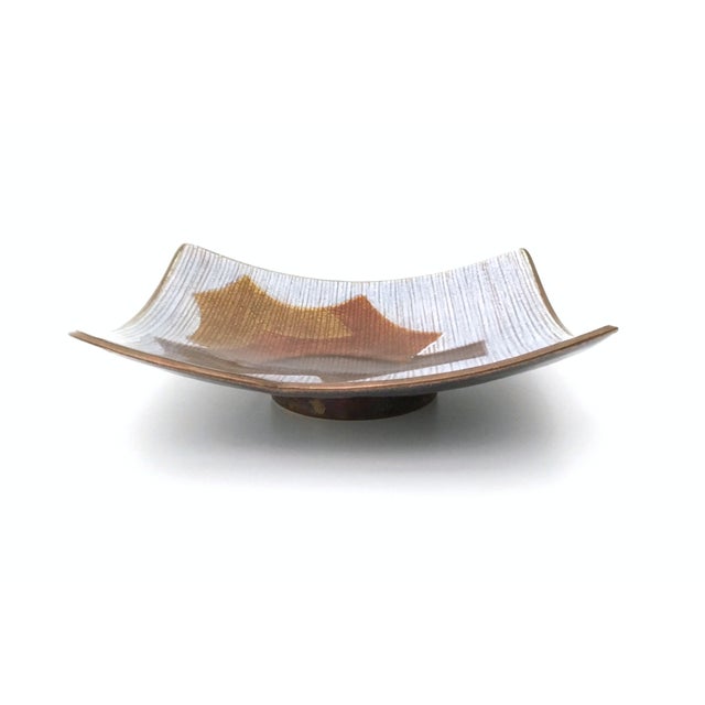 Made in Italy, 1960s. This catchall is in lacquered copper and shows a geometrical design with autumn color shades. It is...