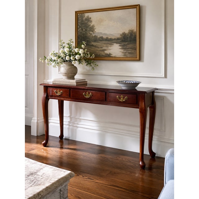 A charming vintage Queen Anne style console table featuring graceful cabriole legs, a rich mahogany finish, and three...