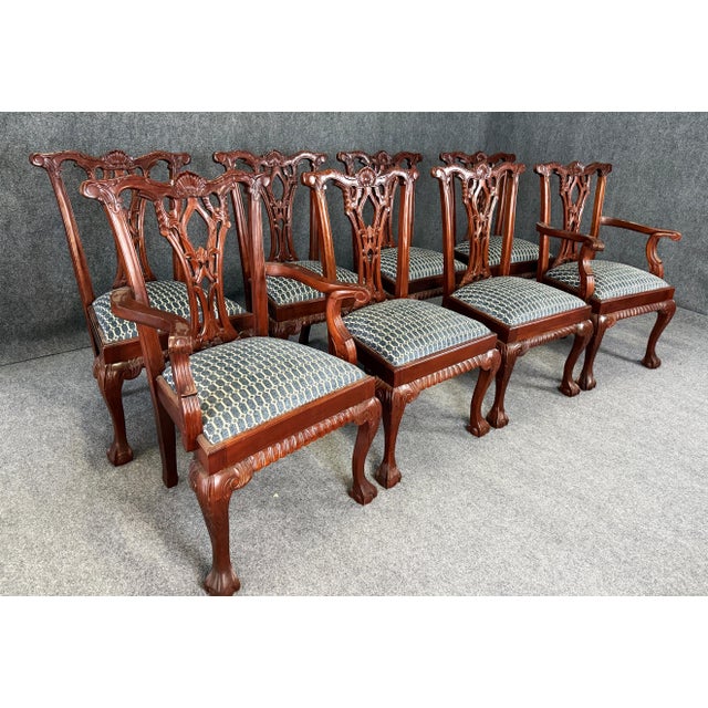 This set of eight solid mahogany dining chairs features finely carved pierced splat backs with shell crest rails, cabriole...