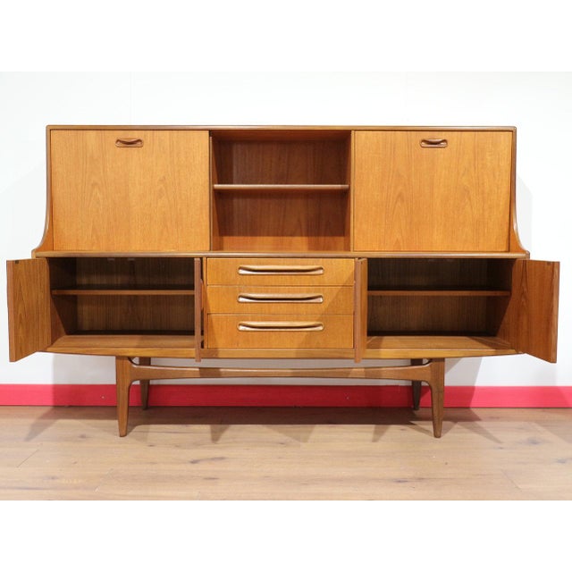 A stunning tall credenza by renowned British furniture maker G Plan, this Mid Century Modern Vintage Teak Credenza Hutch...