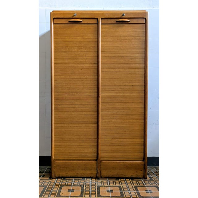 Charming, fully restored, blond oak filing cabinet with a rolling shutter. The cabinet is in excellent condition. A...