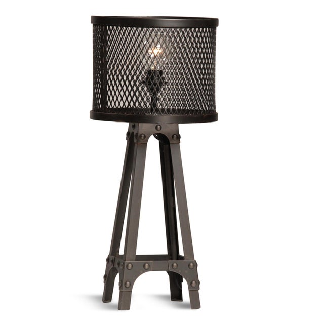 Industrial style table lamp with heavy duty iron frame with studs and iron mesh barrel lamp shade. Antiqued black finish....