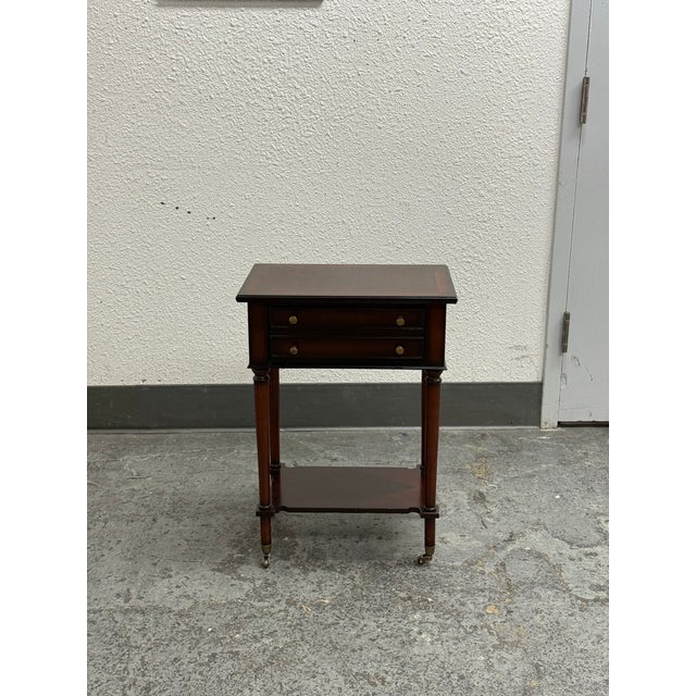 Design Plus Gallery presents a Two Drawer Occasional Table on Casters from Bombay Company. This compact wood table has a...