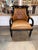 Handsome Regency-style armchair featuring caramel brown tufted leather, nailhead trim, and a dramatic ebonized wood frame....