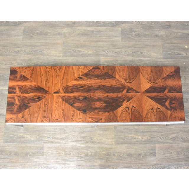 A stunning mid century modern rosewood coffee table with a polished chrome base in the style of Milo Baughman....