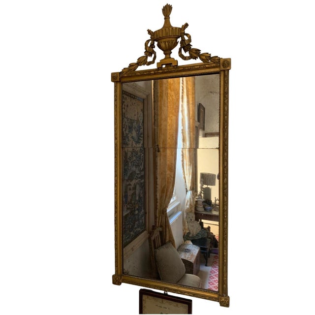 A C19th gilt mirror with nicely aged original plate and urn and swag decorative detailing at the top This piece is...
