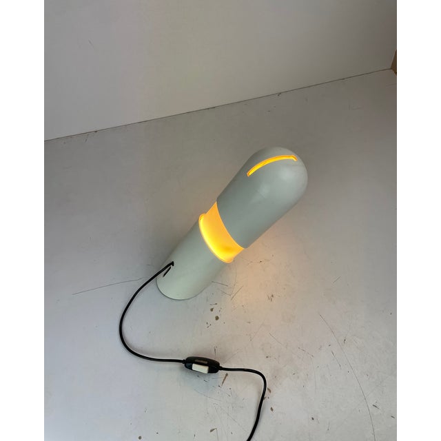 Beautiful space age table lamp made of white abs plastic, with a distinctive cylindrical, capsule-shaped body and an...