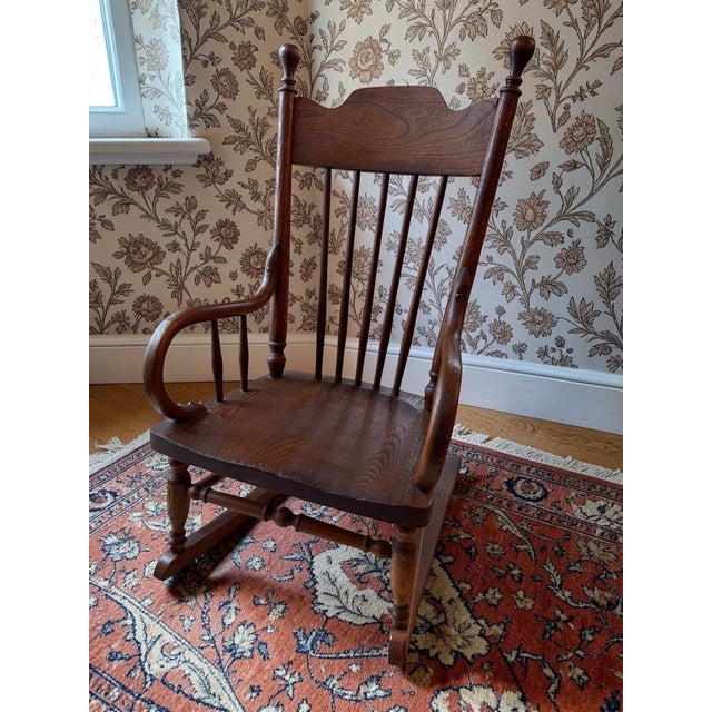 Offering a patina-rich child's rocking chair, dating from the late 19th to early 20th century. Turn of the century...