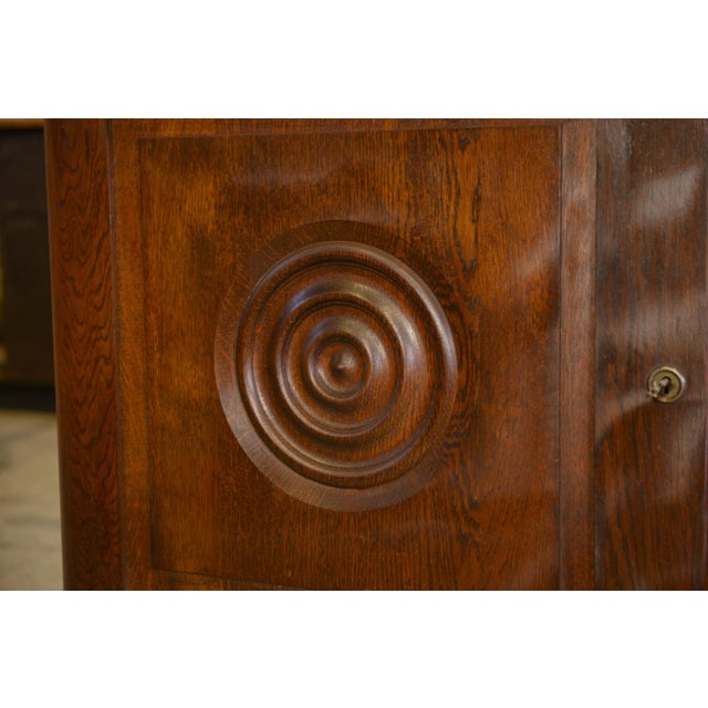 A striking oak sideboard, typical of 1950s French furniture, with a warm and substantial presence. The panelled fronts are...