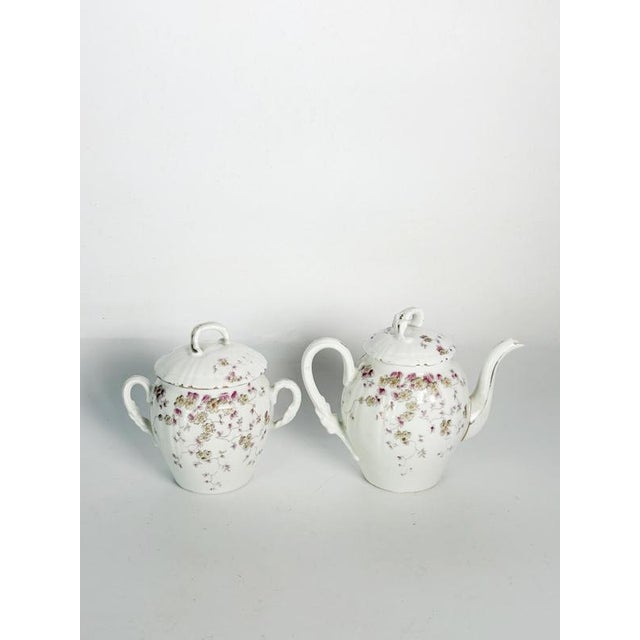 Elegant vintage French tea service comprising a teapot and matching covered sugar bowl in white porcelain. Both pieces are...