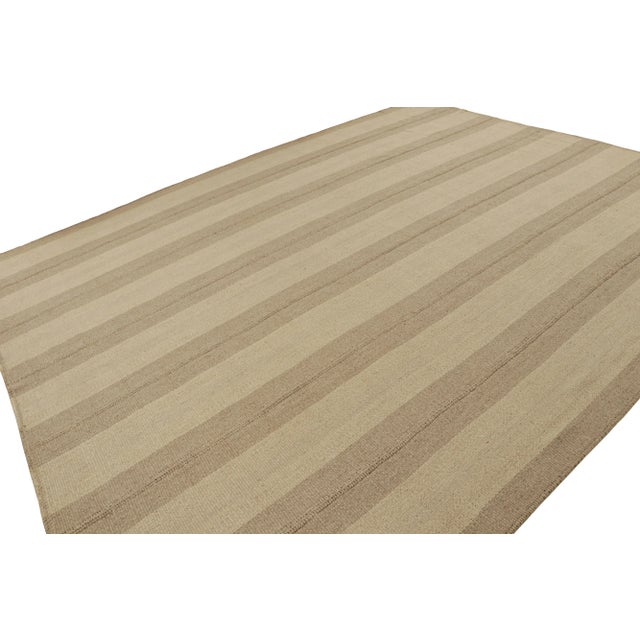 Handwoven in wool, a 12x15 Kilim in beige and taupe stripes and brown accents, from a bold new line of contemporary...