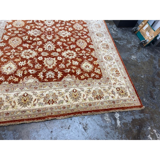 Design Plus Gallery presents a 7ft 11in × 9ft 11 Pak-Veg Hand-Knotted Wool Area Rug. The design showcases a rust-toned...