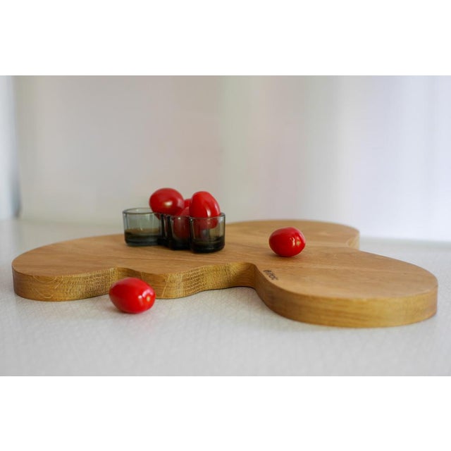 A finely crafted oak serving platter featuring the iconic “Savoy” silhouette from a limited Alvar Aalto collection by...