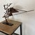 Welded scrap steel sculpture by Iowa Sculptor David Owens. It is welded to a metal plate base with black paint