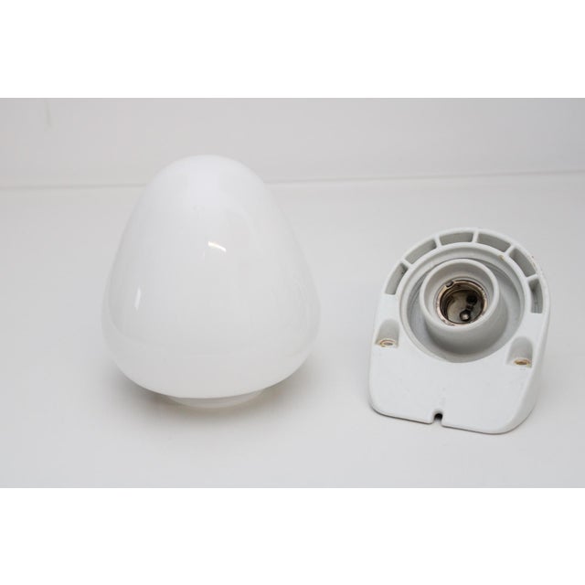 White glazed porcelain base with screwed up opal glass shade, large frame E27, This piece is attributed to the mentioned...