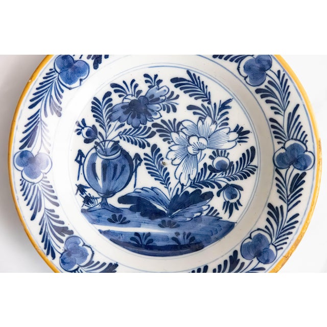 A gorgeous antique 18th-Century Dutch Delft faience floral plate. This lovely plate has a hand painted flower pot center...