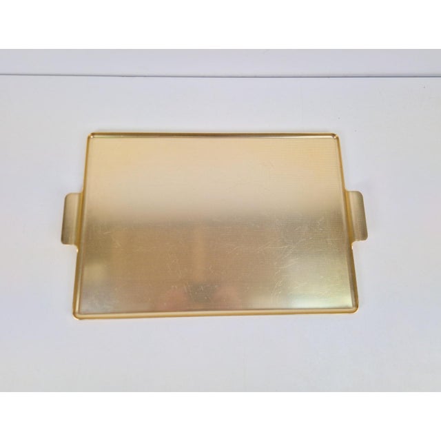 Large gold-anodised aluminium tray featuring a ribbed extruded rim and handles; hand-finished and assembled. Designed and...