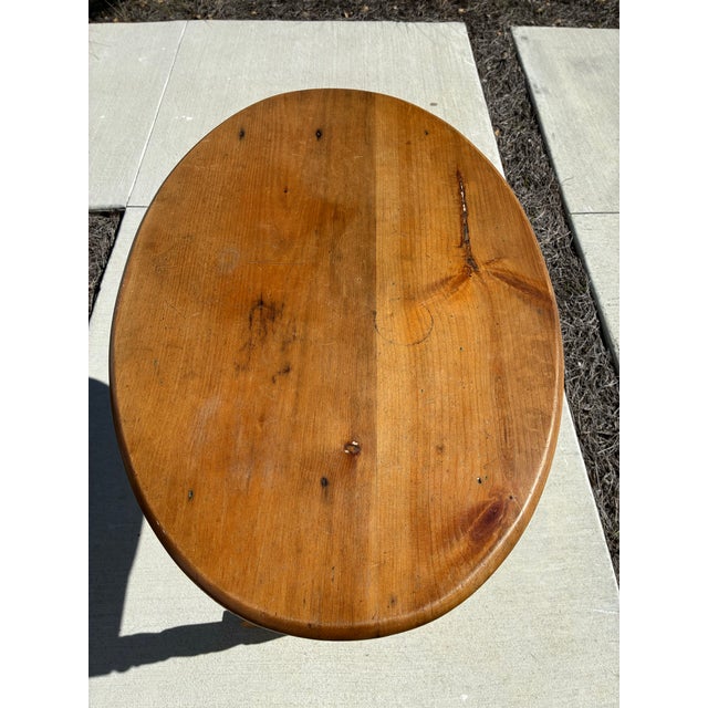 A charming late 19th-century American country pine oval side table featuring turned double-spindle legs, a matching turned...