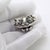 This vintage silver animal sculpture depicts two kittens resting inside a woven basket, crafted as a desktop accent,...