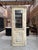 This tall corner cabinet has been completely restored. It features a glass door that opens to reveal two shelves and a...