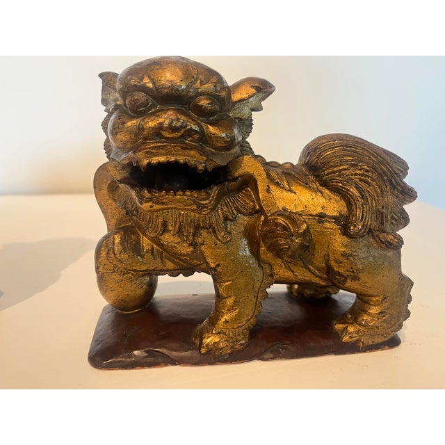 Matching original pair male and female foo dogs. Hand-carved solid wood with original gold leaf gilding over a reddish-...