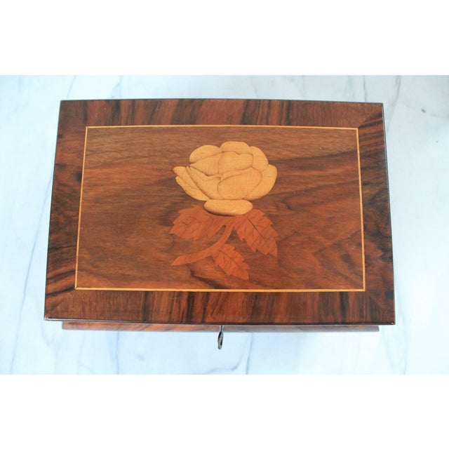 Vintage footed wood marquetry inlay trinket box with a rose design. Includes key. Locking mechanism is in working order....