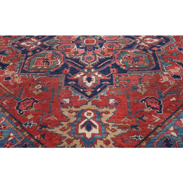 An early 20th century Persian Heriz antique rug displays a characteristic geometric eight-lobed medallion with vines and...