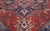 An early 20th century Persian Heriz antique rug displays a characteristic geometric eight-lobed medallion with vines and...