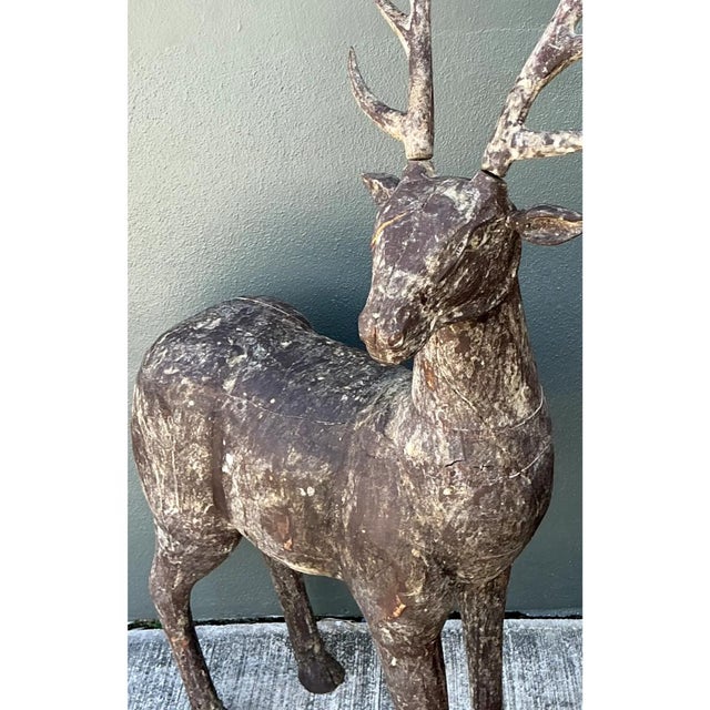 This pair of vintage carved wood deer sculptures commands attention with its near life-size scale and expressive,...