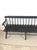 This antique Deacon's bench features hardwood construction, chippy black painted finish, sculpted arms, and stretcher base.