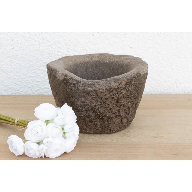 This heavy stone mortar is a relic of the "Old World" kitchen. Carved from a single block of solid granite, it was...