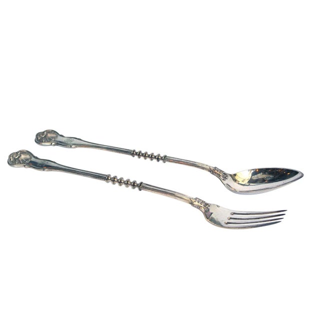 An antique Sy & Wagner serving set. Spoon:2" x 12.75" x 1.5", Fork: 1" X 12.75"x1".