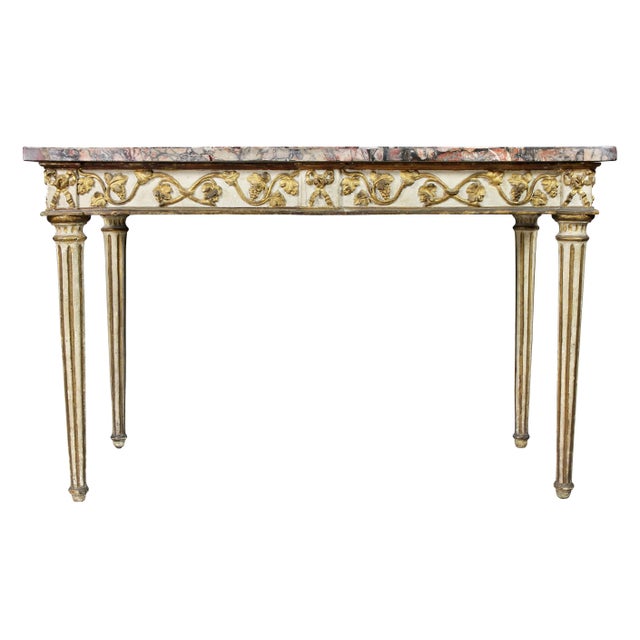 With a rectangular veneered marble top over a conforming frieze decorated with trailing grape vine and leaves and grapes,...