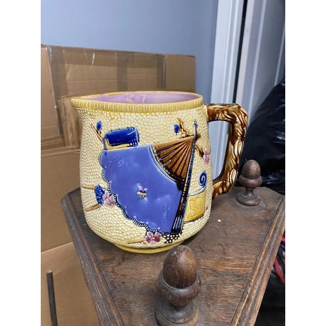 Elegant large Victorian Majolica pitcher inspired by the Japon decorated with flowers, a large fan, a flag on pastel...