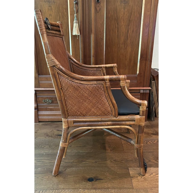 Offering this British Colonial styled Arm chair with curved rattan frame, woven paneled back and side panels, upholstered...