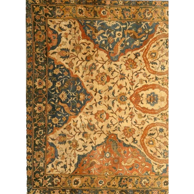 An Indian antique carpet, the sand field with floral motifs and an enlarged red ochre cloud band form framed by blue and...
