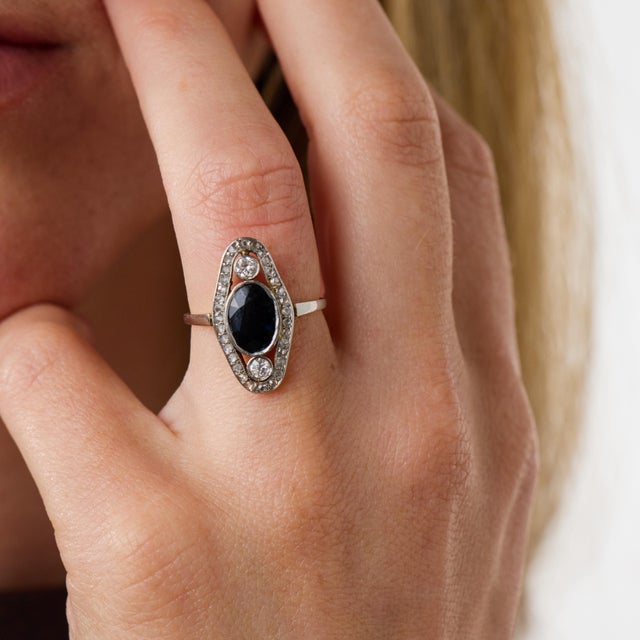 This elegant Edwardian sapphire and diamond ring is a beautifully refined jewel from the 1910’s, centered by an oval cut...