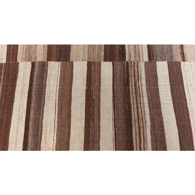 This exceptional vintage Kilim rug from the 1950s is a harmonious tribute to minimalist design, earthy color palettes, and...