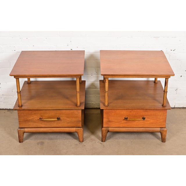 An exceptional pair of Mid-Century Modern or Hollywood Regency sculpted walnut and faux bamboo nightstands or end tables...